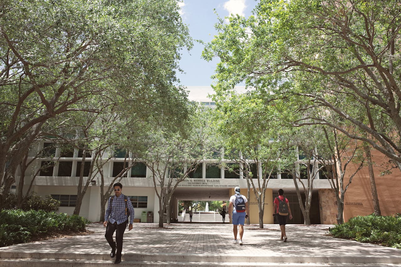 why-choose-us-01 Students walking through a sunlit university campus in Coral Gables, Florida.
