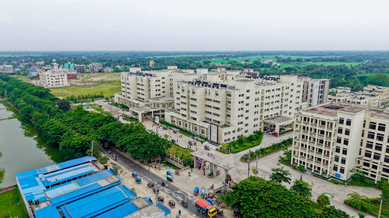 why-choose-us-02 Aerial view of the Kushtia Medical College campus showing modern architecture and lush surroundings.
