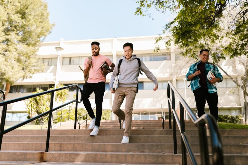 The Art of Drawing Readers In: Your attractive post title goes here Three college students walk down stairs on campus, carrying books and backpacks, on a sunny day.